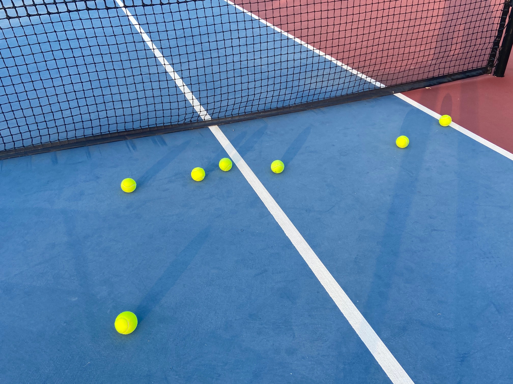 Balls near net of tennis court.