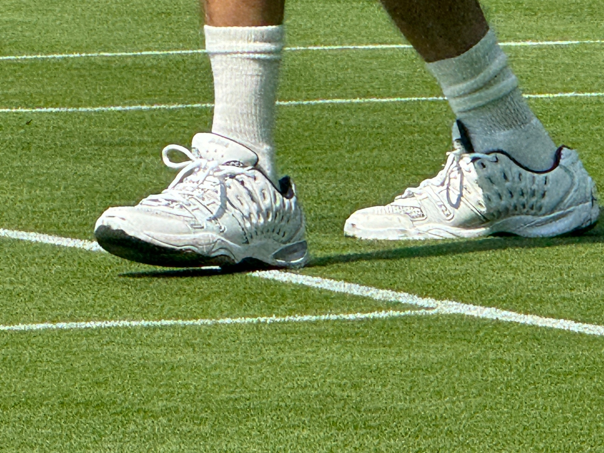 Tennis shoes on a grass court.