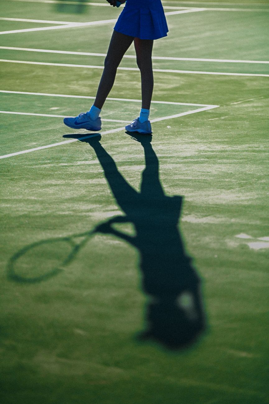 tennis player shadow on court action shot