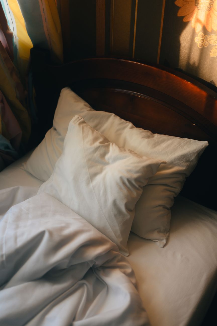 cozy unmade bed in warm sunlight