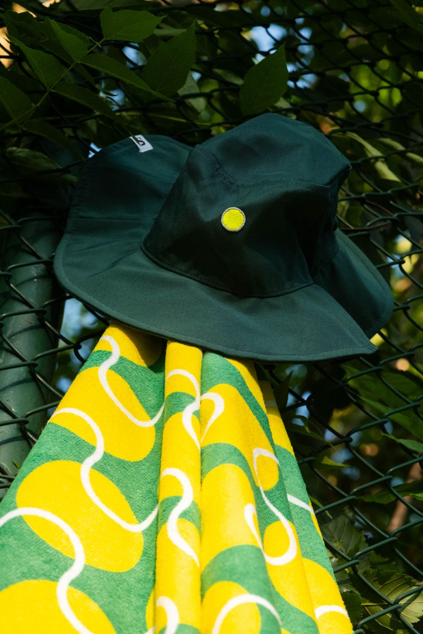 green bucket hat and vibrant towel outdoors